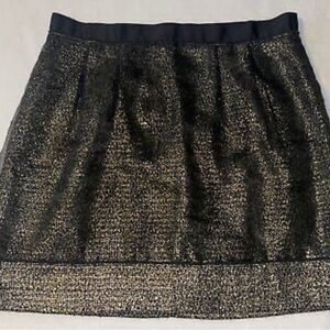 Black overlay skirt with gold trim.